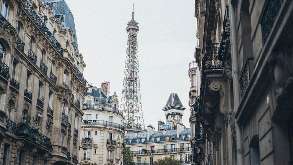 Image de la tour Eiffel derrière des immeubles de type haussmanien