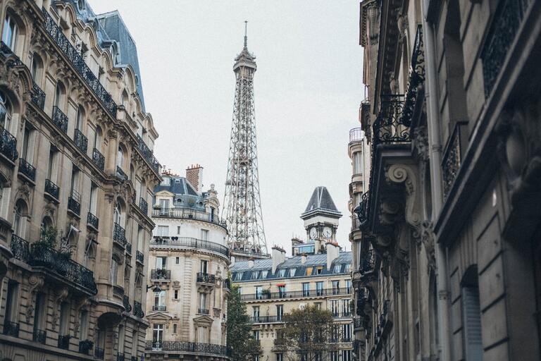 Image de la tour Eiffel derrière des immeubles de type haussmanien